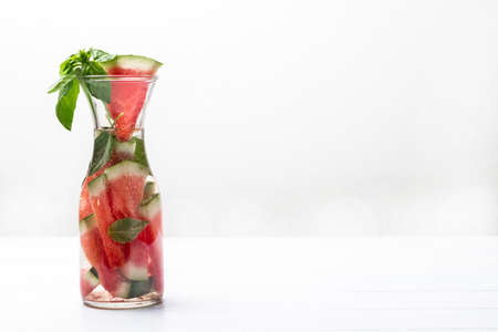 Sparkling watermelon water with green basil in glass jar. copyspace. white background.の写真素材