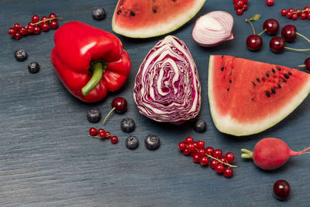 Piece of watermelon, half a cabbage, cherries, red currants on blue background. copyspace. top view.の写真素材