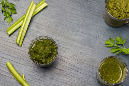 Green smoothie in glasses. Celery stalks on table. copyspace. flat lay. gray backgroundの写真素材