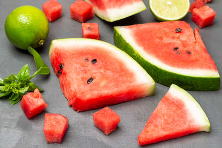 Watermelon slices, lime and basil sprig. top view. gray background.の写真素材