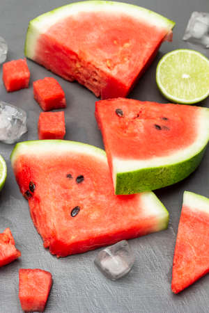 Watermelon slices, lime half and ice on a gray background. top view.の写真素材