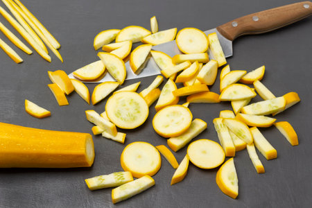 Sliced yellow zucchini and a kitchen knife. top view. gray backgroundの写真素材