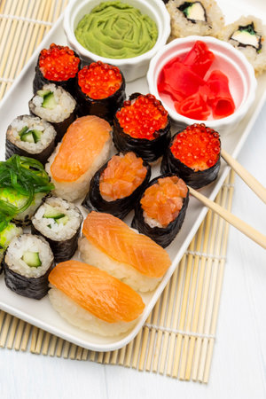 Sushi set, bowls with wasabi and pink ginger on a plate. flat lay. white background.の写真素材