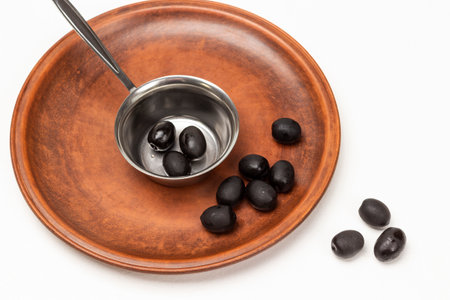 Black olives in a metal bowl and on a ceramic plate. white background.の写真素材