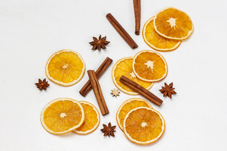 Cinnamon sticks, star anise and orange chips on white background. flat layの写真素材