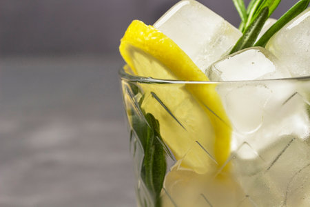 Lemon and pieces of ice in a glass. Part of the frame. copyspace. close up. gray background.の写真素材