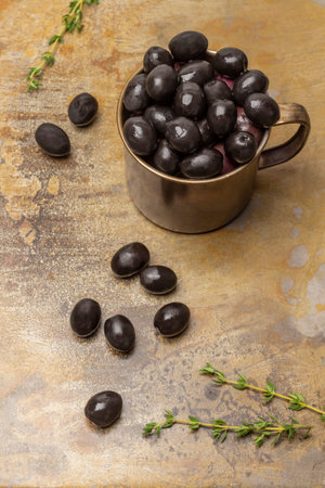 Black olives in a metal mug and on the table. top view. Rusty backgroundの写真素材
