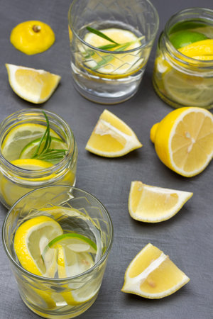 Lemon slices on table. Glasses with summer lemon drink. Top view. Grey backgroundの写真素材