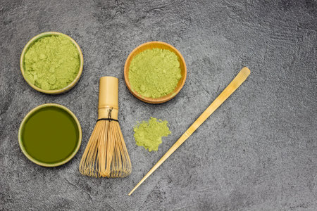 Matcha green tea and matcha powder. Bamboo whisk and measuring spoon. copyspace. flat lay. black backgroundの写真素材