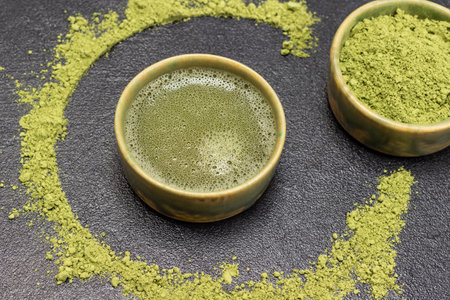 Bowl of matcha powder and bowl of matcha tea. Matcha powder on table. top view. black backgroundの写真素材