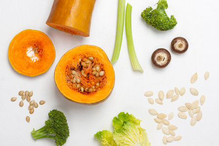 Celery stalks, broccoli and Chinese cabbage, mushrooms, pumpkin seeds and chopped pumpkin. flat lay. white background.の写真素材