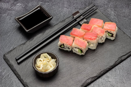 Sushi with tuna and ginger in bowl on stone board. Soy sauce and chopsticks. top view. black backgroundの写真素材