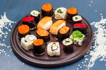 Sushi set on cutting board. Rice on the table. top view. blue background.の写真素材