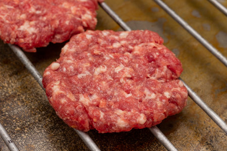 Raw beef burgers on grill. close up. top view. Rusty metal background.の写真素材