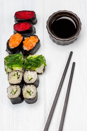 Set of sushi and soy sauce in a bowl, chopsticks. flat lay. white background.の写真素材