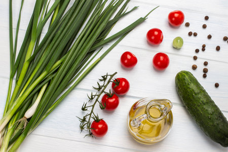 Cucumber, allspice, bottled olive oil and green onion. Set of fresh vegetables. flat lay. white background.の写真素材
