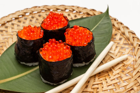 Sushi nori with caviar on green leaf on wicker plate. top view. white backgroundの写真素材