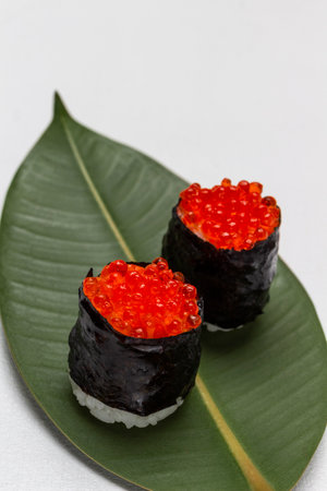 Sushi nori with caviar on green leaf. copyspace. top view. white backgroundの写真素材