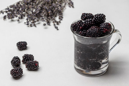 Blackberry infused water in glass mug. Lavender on table. top view. gray background.の写真素材