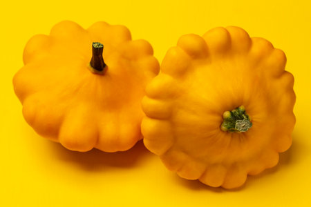 Two yellow patissons on a yellow background. top viewの写真素材