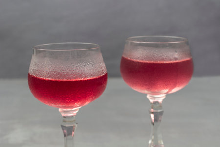 Two wine glasses with cooling drink. Drops of water on misted glass of wine glass. close up. gray backgroundの写真素材