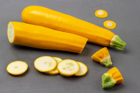 Whole zucchini and sliced yellow zucchini. top view. gray background.の写真素材