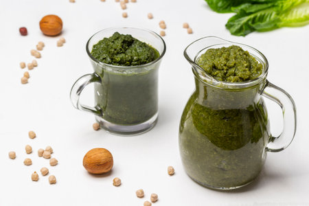 Green smoothie in glass jars. Nuts and chickpeas on the table. top view. white background.の写真素材