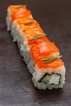 Sushi with salmon and cucumber close-up. top view. brown backgroundの写真素材