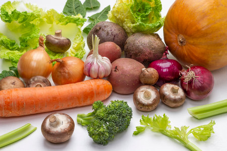 Carrots, mushrooms, pumpkin, cabbage leaves, potato tubers and broccoli on white. top viewの写真素材