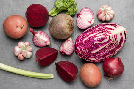 Set of colored vegetables on gray background. Cabbage, potatoes, chopped beets, garlic and broccoli. flat layの写真素材