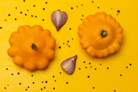 Two yellow patissons and purple onion slices. flat lay. yellow background.の写真素材