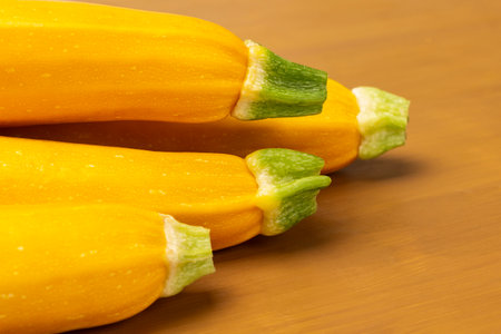 Yellow zucchini with green tails. close up. yellow background.の写真素材