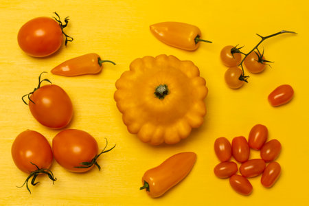 Yellow squash and peppers, tomato sprigs. flat lay. yellow background.の写真素材
