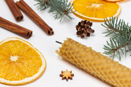 Wax candle, cinnamon sticks and dry orange slices. top view. white background.の写真素材
