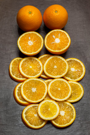 Sliced oranges and two whole oranges. brown background. flat layの写真素材
