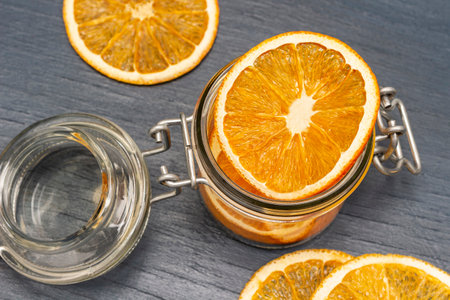 Dry orange slices in glass jar and on table. Christmas decorations. flat lay. blue background.の写真素材