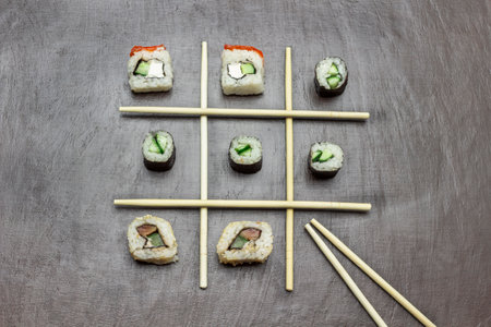 Sushi among chopsticks. copyspace. flat lay. brown background.の写真素材