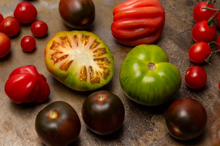 Half a green tomato. Tomatoes of different varieties. top view. Rusty metal background.の写真素材