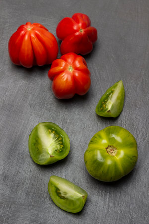 Green and red tomatoes. top view. gray background.の写真素材