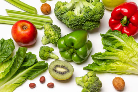 Set of vegetables: broccoli, pepper, lettuce, celery stalks, apple, half kiwi and nuts. flat lay. white background.の写真素材