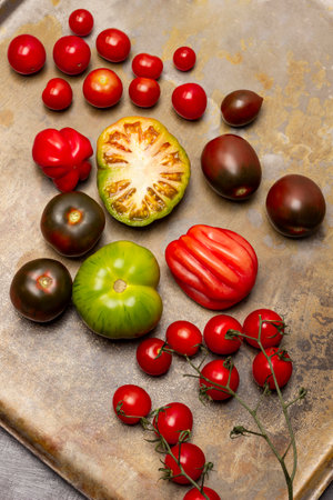 Red, green and dark red tomatoes. Chili tomato sprigs. flat lay. Rusty background.の写真素材