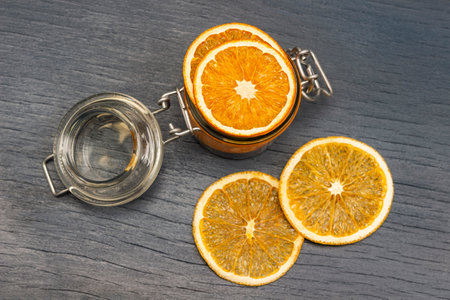 Orange slices in a glass jar and on the table. flat lay. gray background.の写真素材