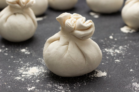 Ready raw dumpling close up. Douhg on table. Black background.の写真素材