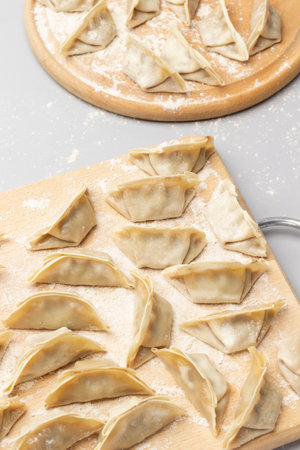 Raw gyoza dumplings on cutting board. top view. gray backgroundの写真素材