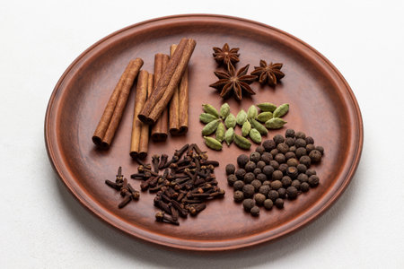 Dry spices on a ceramic plate. Cinnamon sticks, cardamom, allspice and star anise. flat lay. white backgroundの写真素材