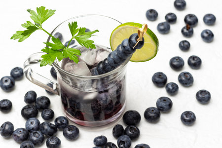 Cooling summer drink with blueberries and ice. Blueberries on the table. top view. white background.の写真素材
