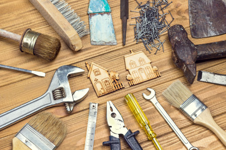 Old, dusty home tools for repair work. Light wooden background. Flat lay
