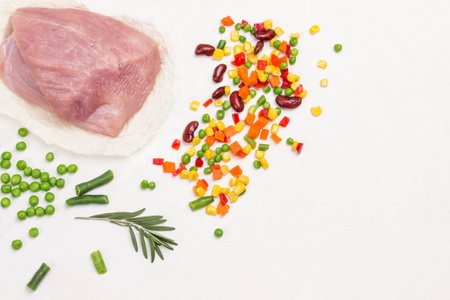 Diet turkey meat with green peas, chopped carrots, beans and corn. Healthy nutrition. Copy space. White background. Flat layの写真素材