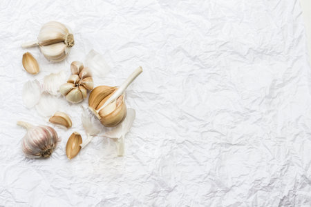 Unpeeled heads and cloves of garlic. Copy space. White background. Flat layの写真素材