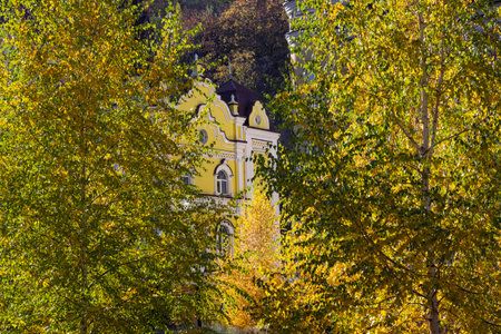 Part of a yellow building among yellow trees. Autumn park in a residential area.の写真素材